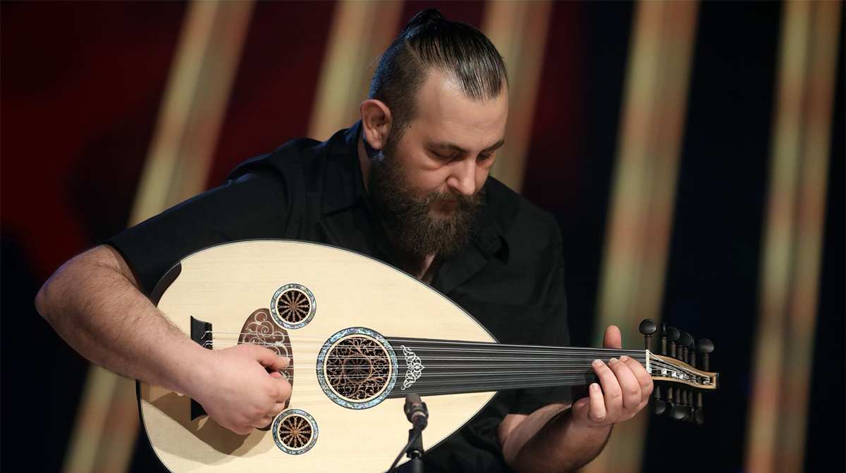 Nazih Borish holds an oud, a guitar-shaped instrument that has intricate carvings